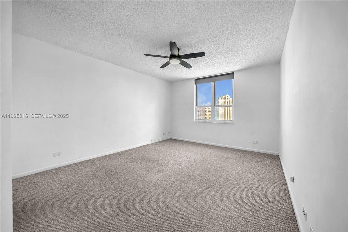 701 Brickell Key Boulevard, Unit 1911 Miami, FL 33131 - Photo 24 of 39 an empty room with windows and ceiling fan