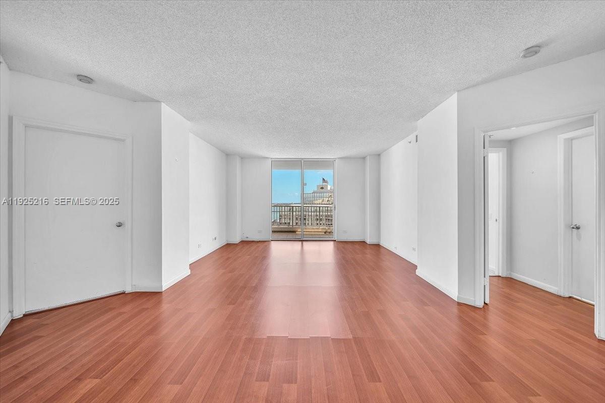 701 Brickell Key Boulevard, Unit 1911 Miami, FL 33131 - Photo 9 of 39 a view of empty room with wooden floor