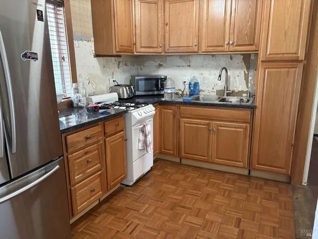 a kitchen with stainless steel appliances granite countertop a refrigerator sink and cabinets
