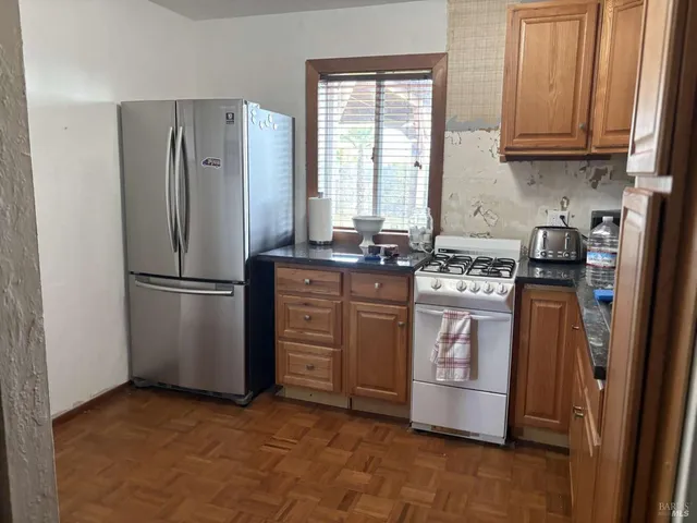 a kitchen with stainless steel appliances granite countertop a stove a refrigerator and a sink