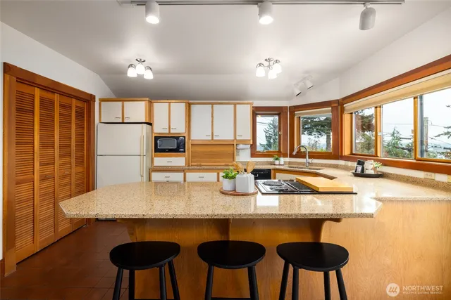 a kitchen with granite countertop a table chairs stove and granite counter top