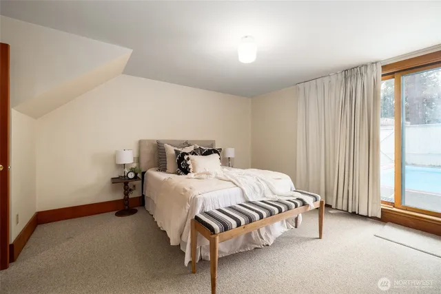 a bed sitting in a spacious bedroom next to a window