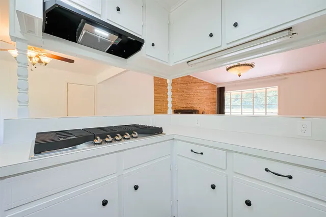 a kitchen with white cabinets and black appliances
