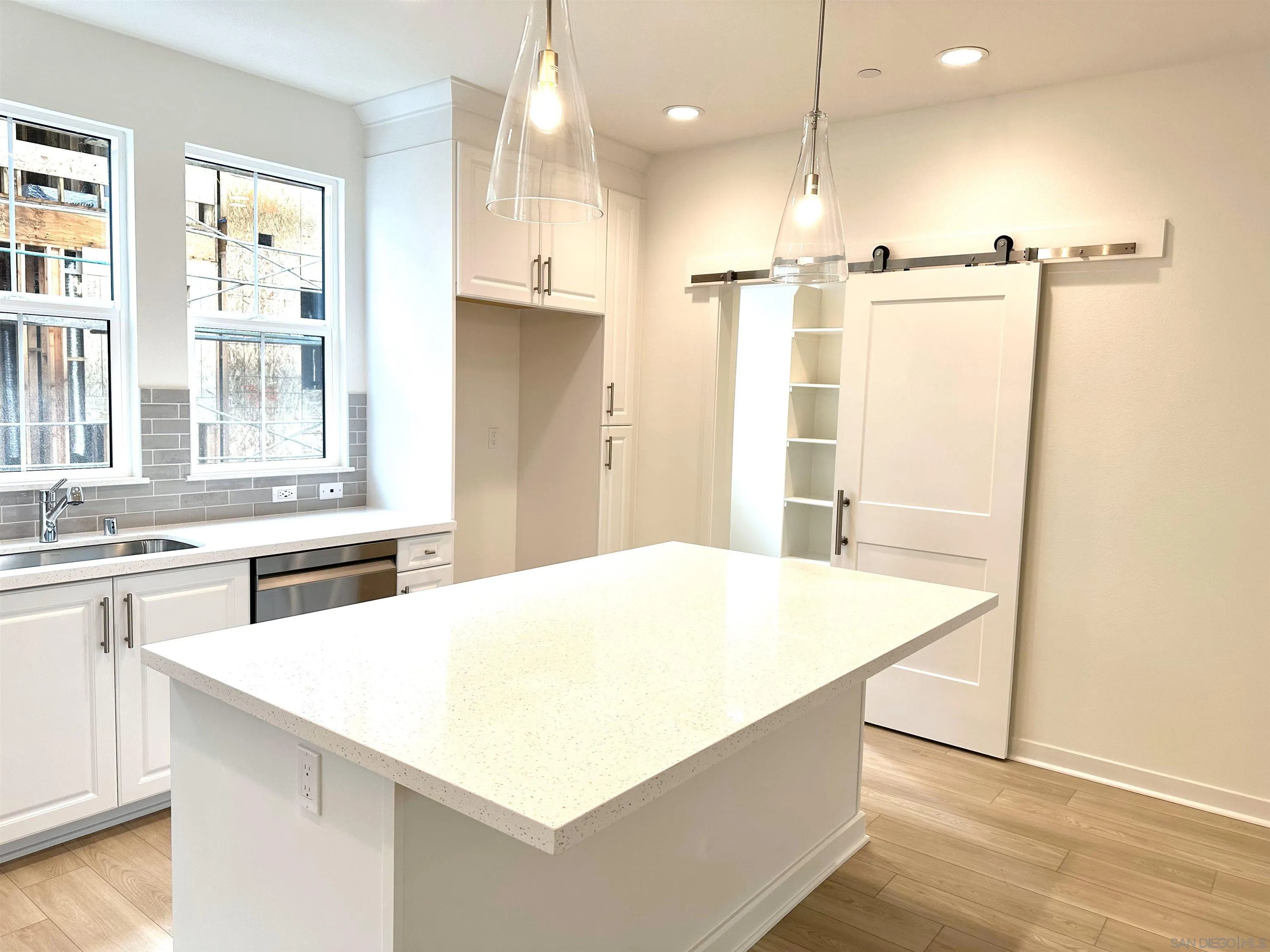 2511 Chamomile Lane Carlsbad, CA 92008 - Photo 15 of 51 a kitchen with a refrigerator a sink and white cabinets