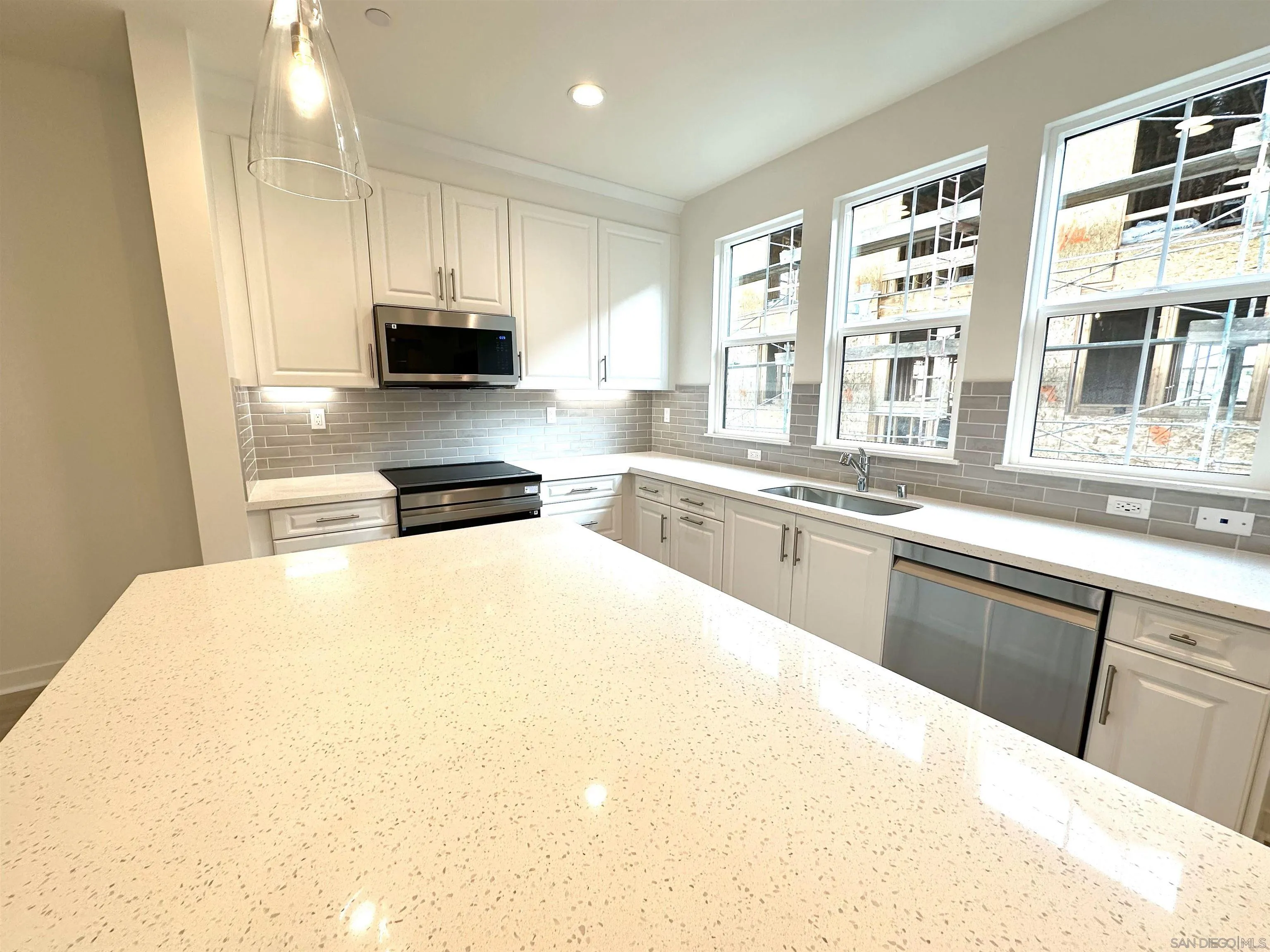 2511 Chamomile Lane Carlsbad, CA 92008 - Photo 4 of 51 a kitchen with a stove a sink a microwave and a refrigerator