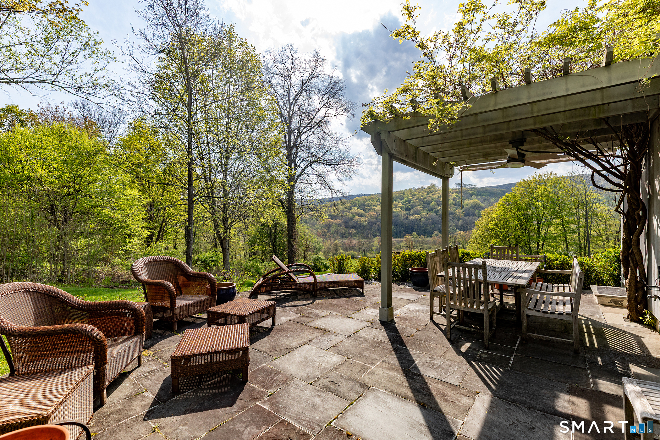 16 Anderson Acres Road Kent, CT 06785 - Photo 4 of 40 a view of a patio with a dining table and chairs under an umbrella with a barbeque