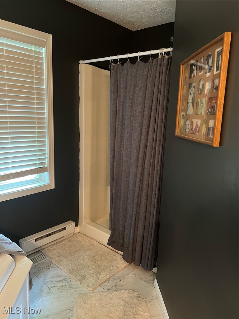 5912 Coen Road Vermilion, OH 44089 - Photo 13 of 28 Bathroom with a shower stall, a textured ceiling, a baseboard heating unit, and vanity