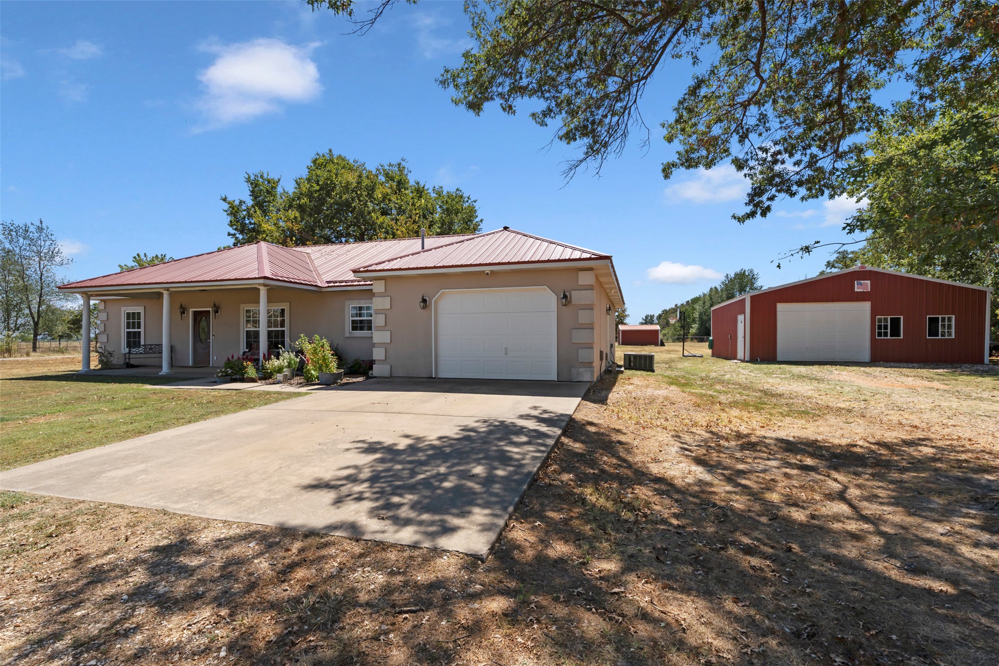 20233 East 570 Road Colcord, OK 74338 - Photo 1 of 39 Stucco exterior residence featuring a metal roof, attached one car garage, and a covered porch