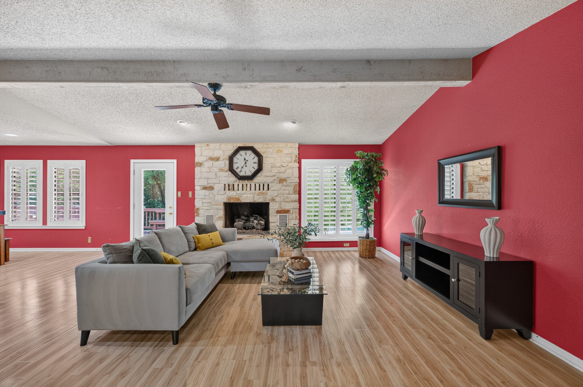 Spacious living room featuring a striking stone fireplace.