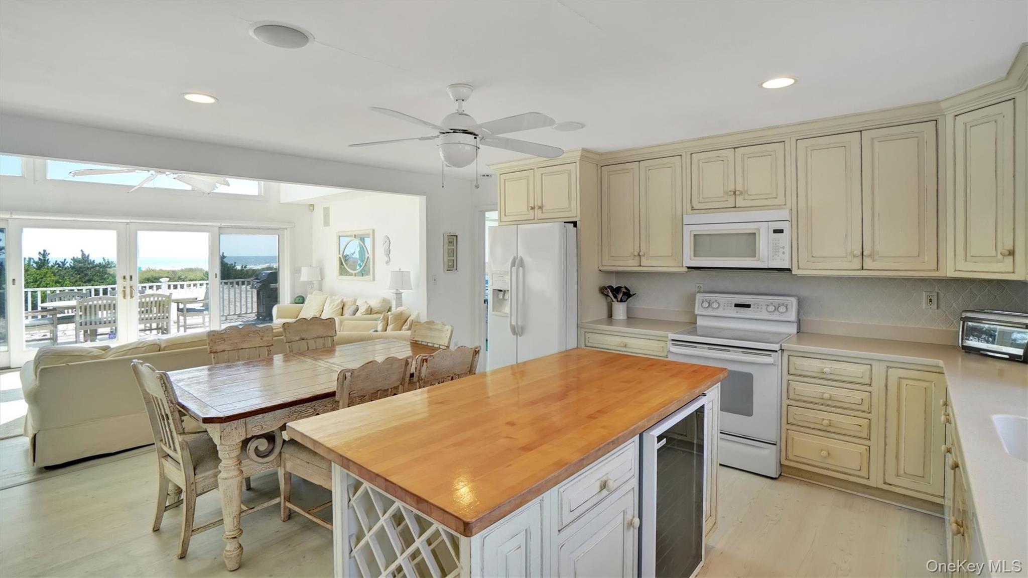 431 Dune Road Westhampton Beach, NY 11978 - Photo 25 of 27 a open kitchen with stainless steel appliances granite countertop a stove a refrigerator a white table and chairs
