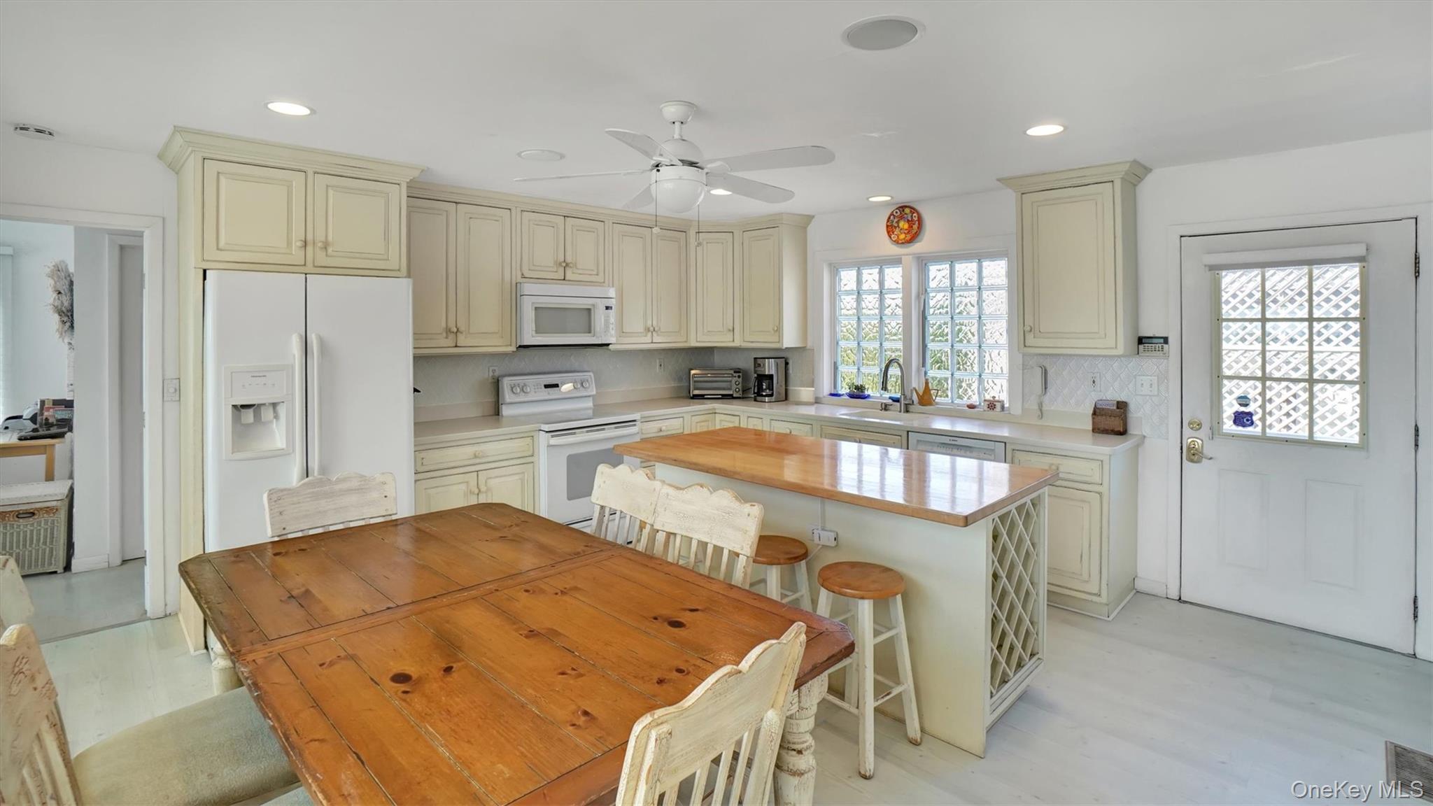 431 Dune Road Westhampton Beach, NY 11978 - Photo 9 of 27 a large kitchen with kitchen island a large window a sink and a refrigerator