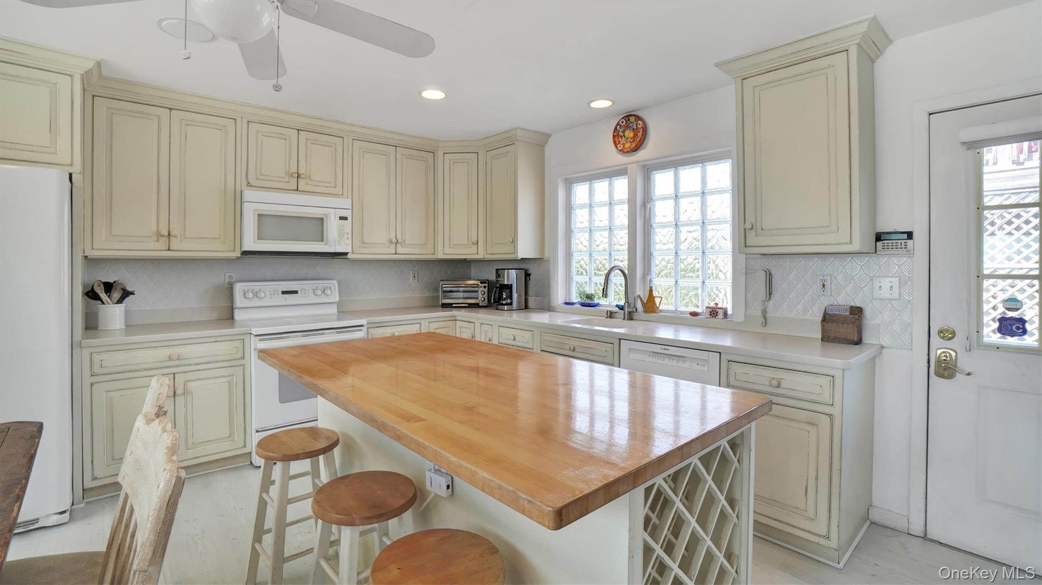 431 Dune Road Westhampton Beach, NY 11978 - Photo 10 of 27 a kitchen with stainless steel appliances granite countertop a sink a stove a refrigerator a microwave and cabinets