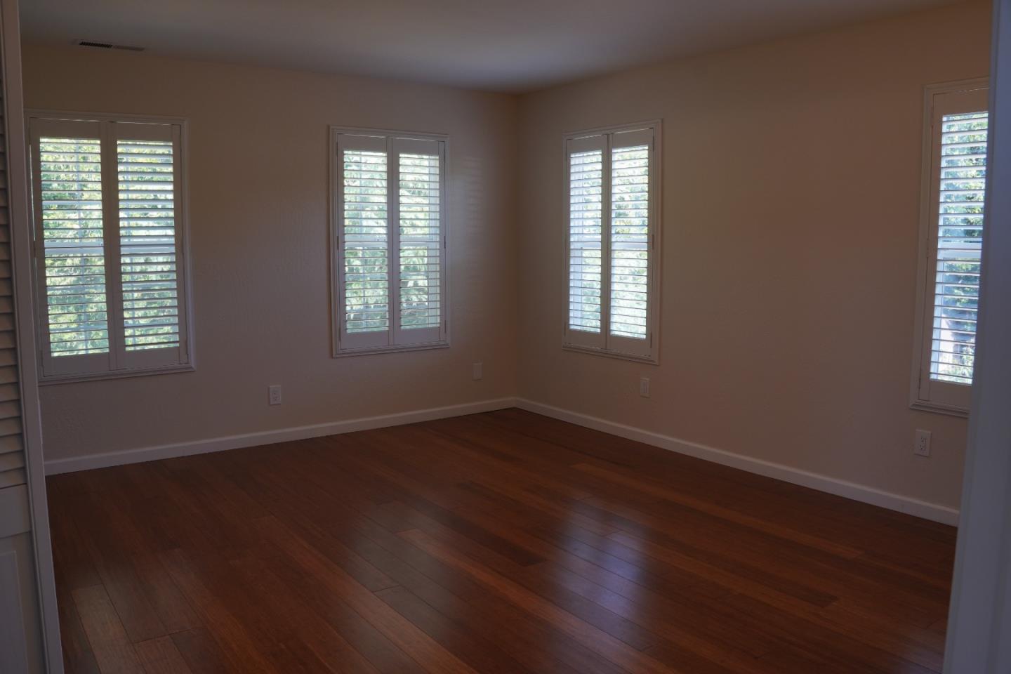 389 Corralitos Road Watsonville, CA 95076 - Photo 12 of 18 an empty room with wooden floor and windows