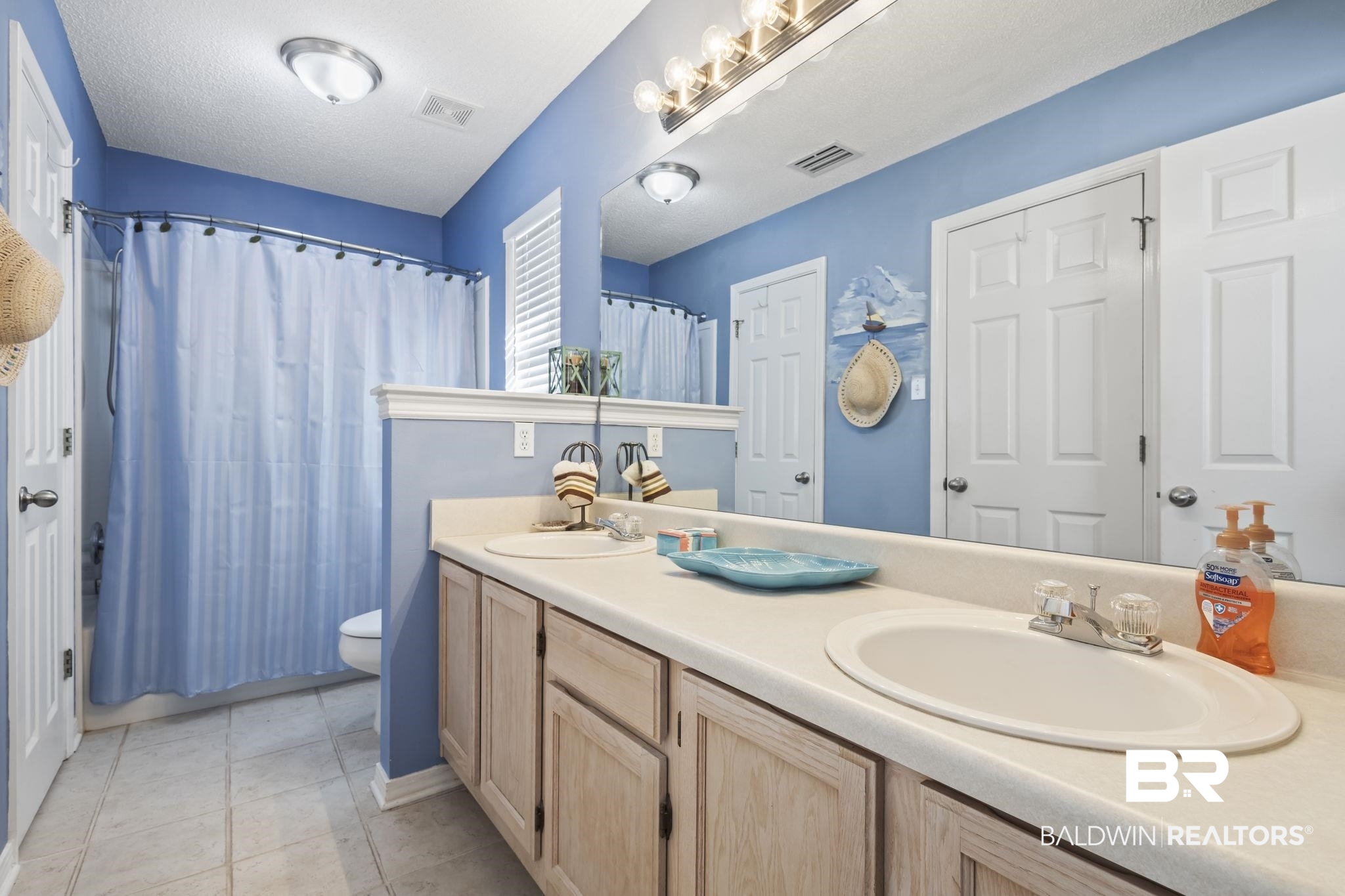 7946 Audubon Drive Foley, AL 36535 - Photo 21 of 25 Bathroom featuring a shower with curtain, vanity, a textured ceiling, toilet, and tile patterned floors