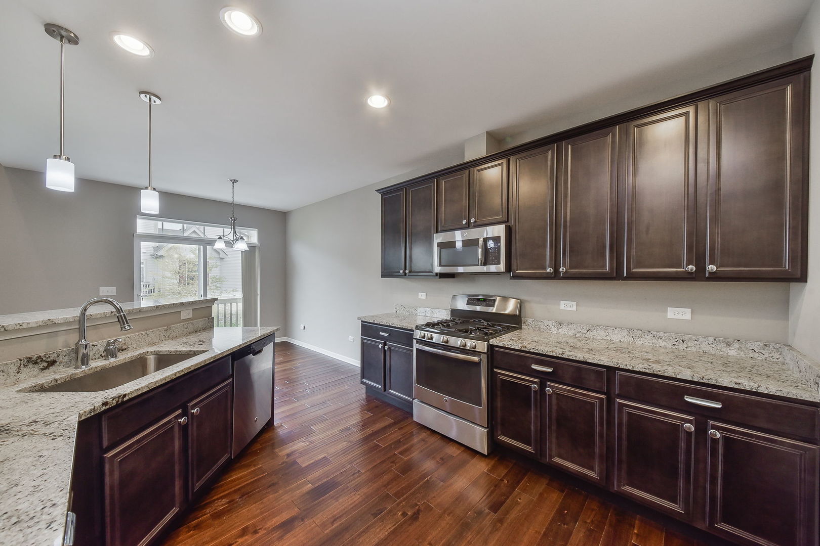 243 Bennett Drive Carol Stream, IL 60188 - Photo 3 of 23 a kitchen with stainless steel appliances granite countertop wooden cabinets stove top oven and sink