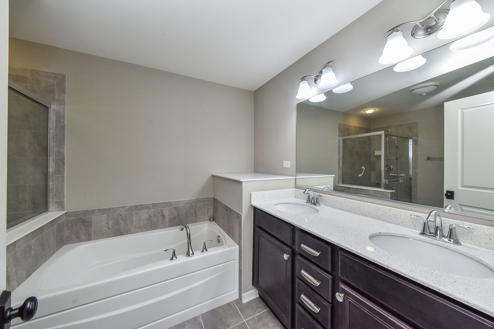 243 Bennett Drive Carol Stream, IL 60188 - Photo 7 of 23 a bathroom with a tub a double vanity sink and a mirror