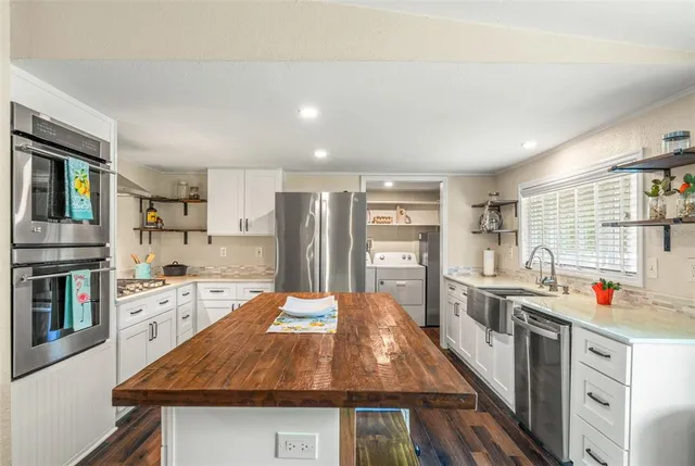 a kitchen with stainless steel appliances granite countertop a stove and cabinets