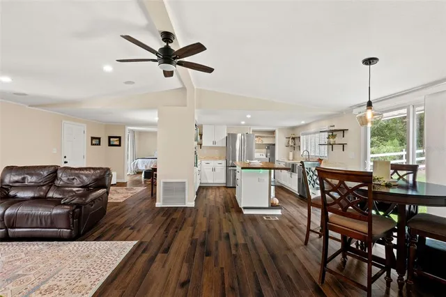 a kitchen with stainless steel appliances kitchen island hardwood floor and dining table