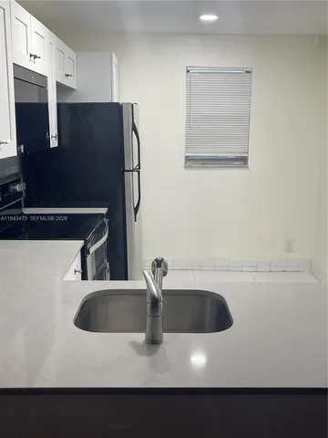 a kitchen with a sink and a refrigerator