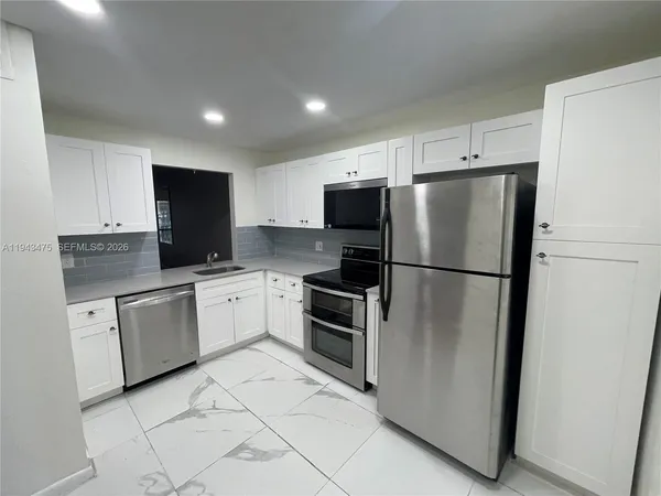 a kitchen with stainless steel appliances a refrigerator sink and microwave