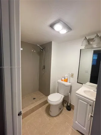a bathroom with a granite countertop toilet a sink and a mirror