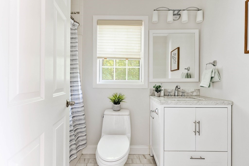 40 Brattle Street, Unit 7 Arlington, MA 02476 - Photo 20 of 25 a bathroom with a granite countertop toilet sink and mirror