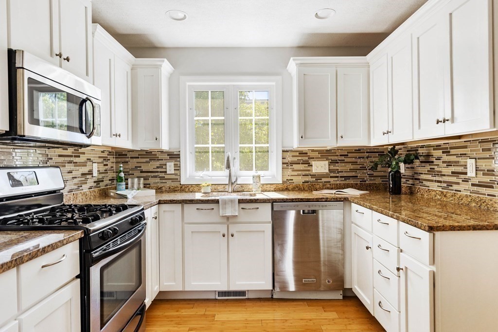 40 Brattle Street, Unit 7 Arlington, MA 02476 - Photo 7 of 25 a kitchen with cabinets stainless steel appliances a sink and window