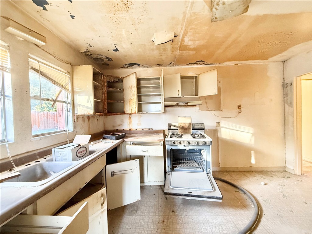 13807 Carson Street Trona, CA 93562 - Photo 20 of 37 a kitchen with a sink stove and cabinets