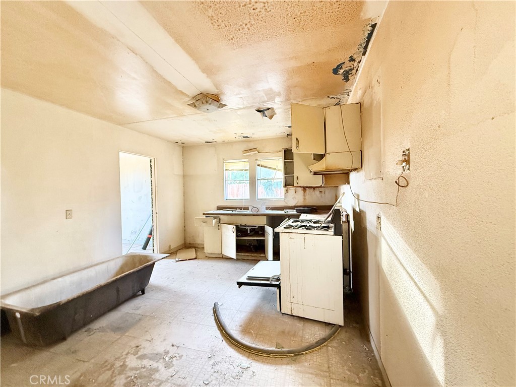 13807 Carson Street Trona, CA 93562 - Photo 10 of 37 a kitchen with a stove a refrigerator and a fireplace