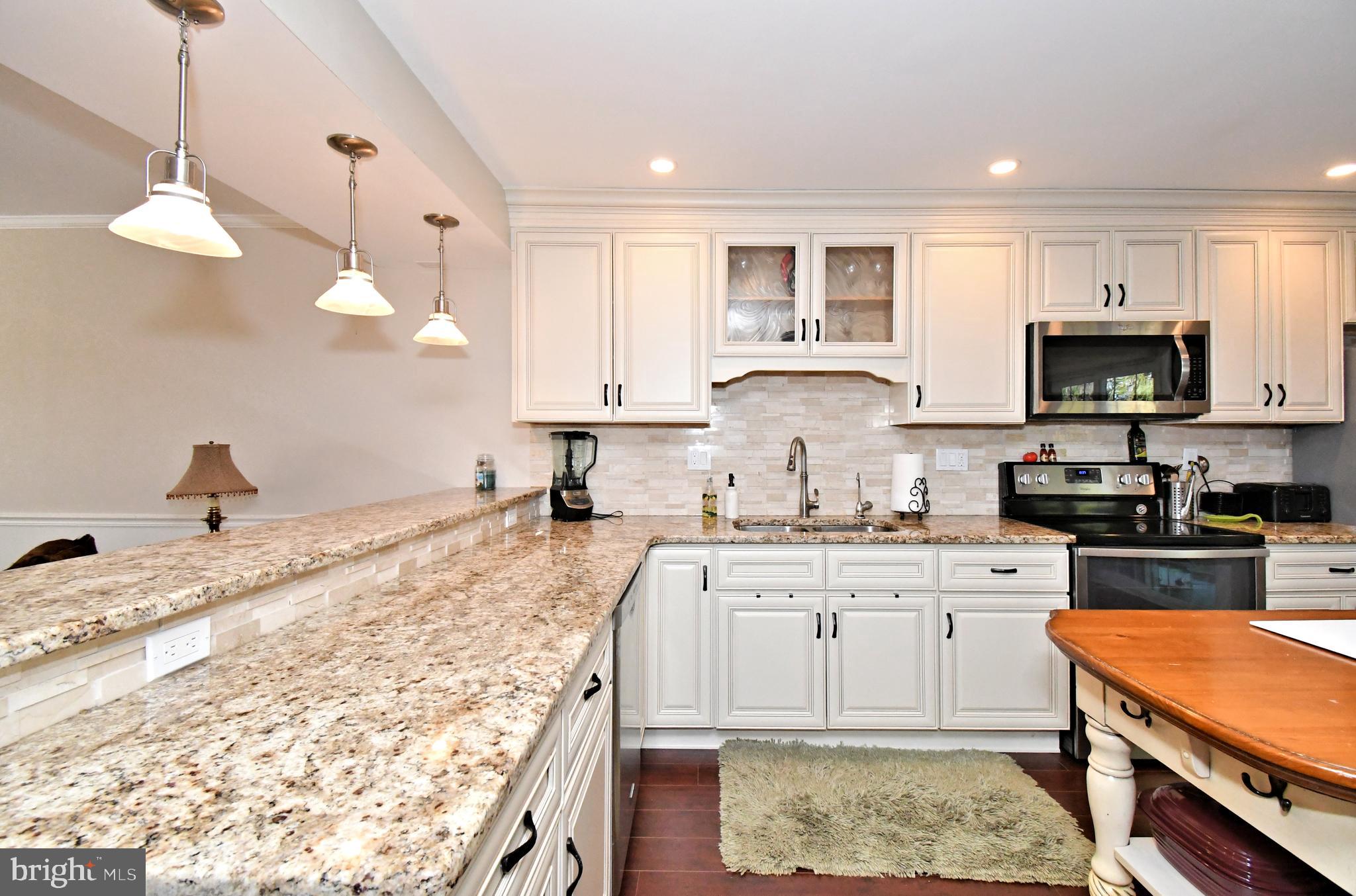 1903 Red Maple Grove Ambler, PA 19002 - Photo 11 of 32 a large kitchen with kitchen island granite countertop a sink a stove a oven a dining table and chairs