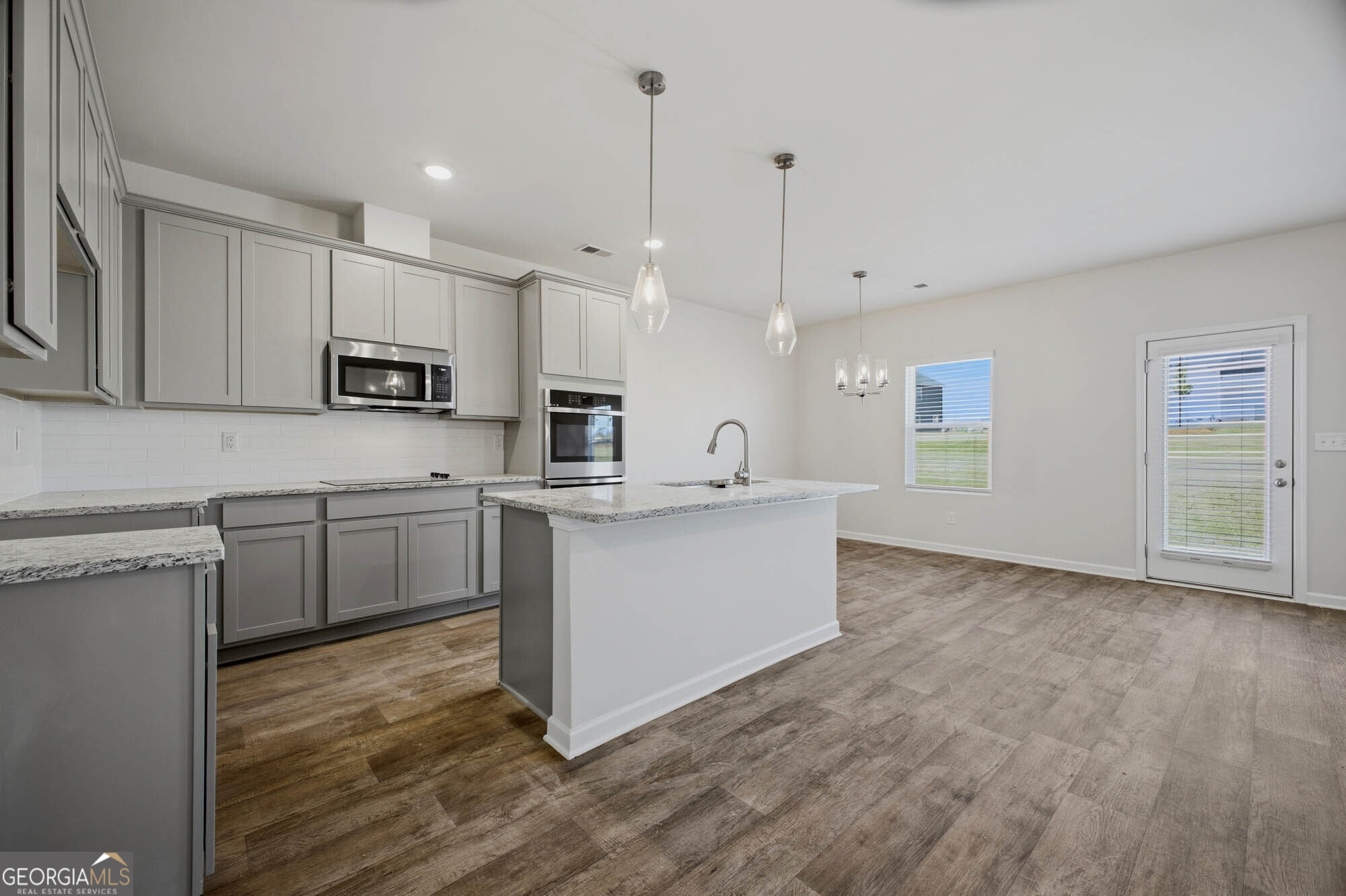 309 Rusty Plow Lane Perry, GA 31069 - Photo 20 of 34 a kitchen with kitchen island a sink cabinets and wooden floor