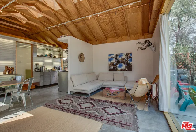 a living room with furniture and a painting on the wall