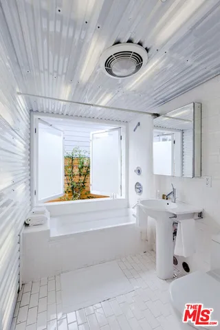 a bathroom with a sink a window and mirror