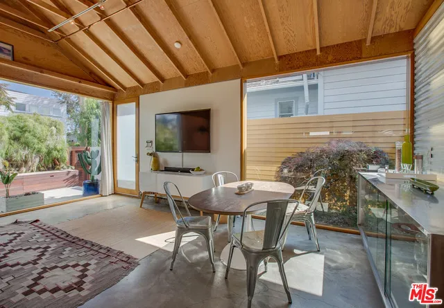 a view of a patio with table and chairs with wooden floor and fence