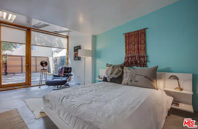 a large bed sitting in a bedroom next to a window