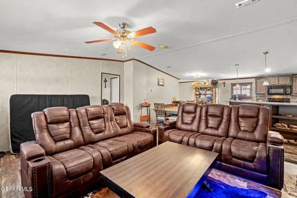 a living room with furniture a ceiling fan and a rug