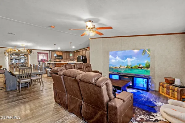 a living room with furniture a flat screen tv and a dining table with wooden floor