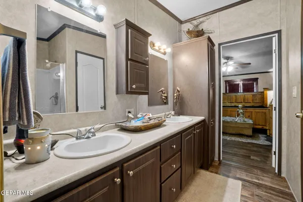 a bathroom with a granite countertop sink a mirror and a shower