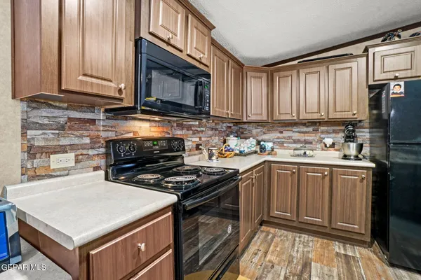 a kitchen with stainless steel appliances a stove a sink cabinets and a microwave