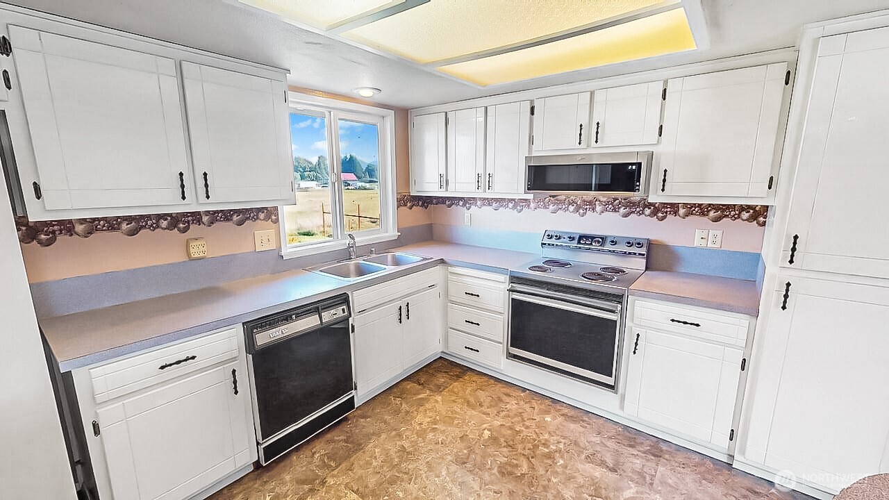 14835 Valley View Drive Mount Vernon, WA 98273 - Photo 4 of 25 a kitchen with granite countertop white cabinets and white appliances