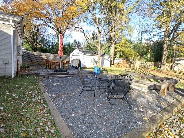 4327 Applegate Road Charlotte, NC 28209 - Photo 24 of 29 a view of a backyard with table and chairs and a barbeque with potted plants and large trees
