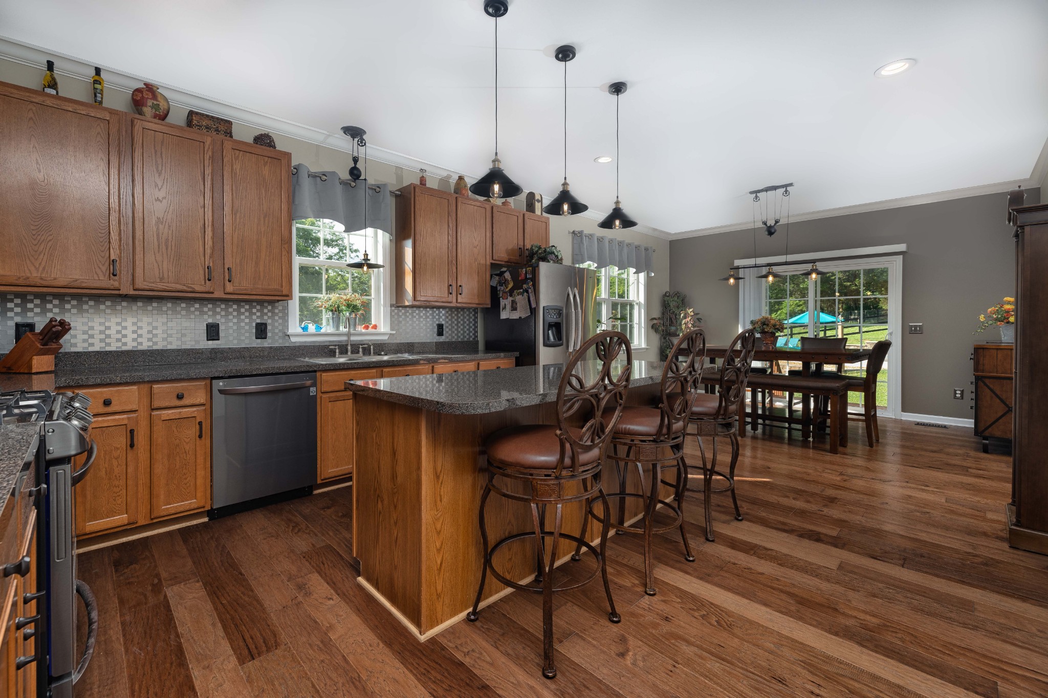 2736 McLemore Road Franklin, TN 37064 - Photo 8 of 50 a open kitchen with stainless steel appliances granite countertop a stove top oven a sink dishwasher a dining table and chairs with wooden floor