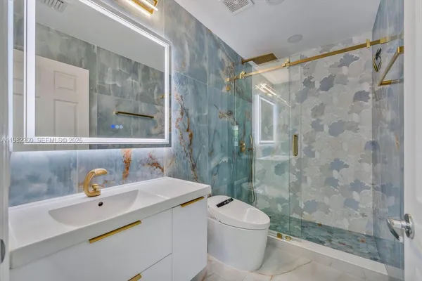 a bathroom with a sink toilet a mirror and shower