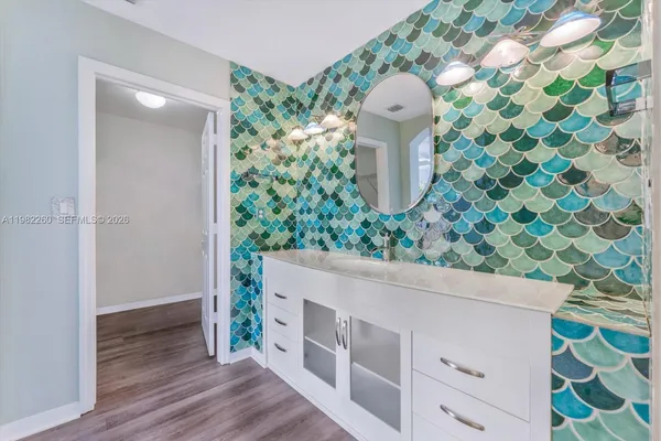 a bathroom with a granite countertop toilet a sink and a shower