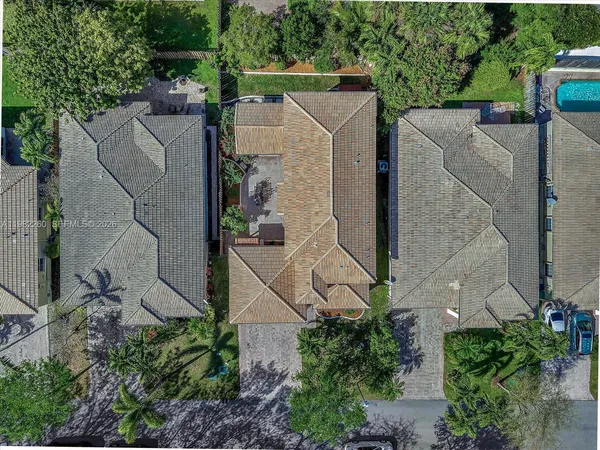 an aerial view of residential houses with outdoor space and trees