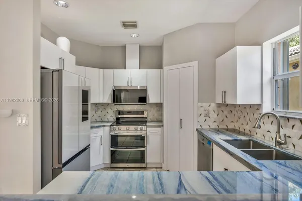 a kitchen with stainless steel appliances a refrigerator sink and microwave