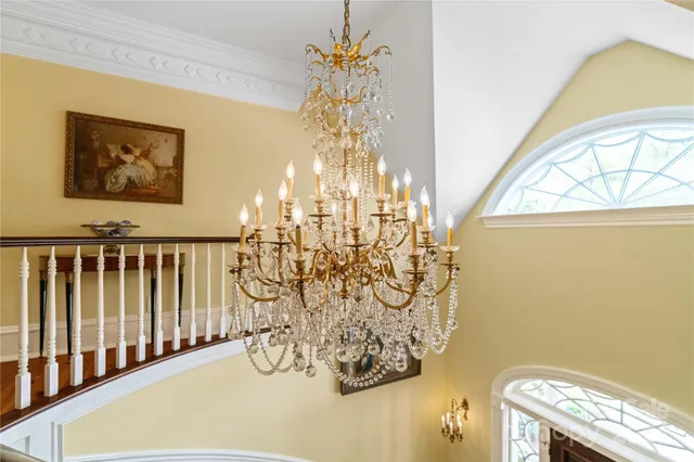 a living room with furniture a chandelier and a fireplace
