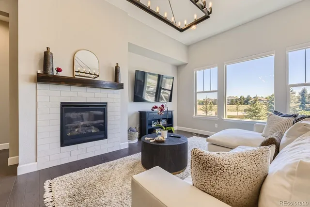 a living room with furniture two window and a fireplace
