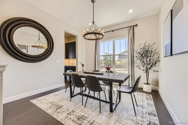 a dining room with chandelier fan and wooden floor