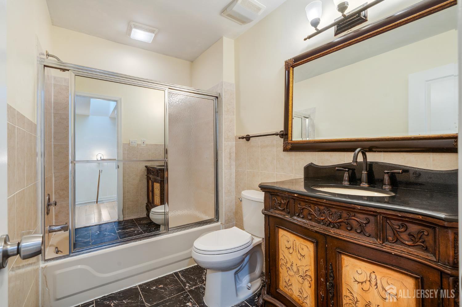 6304 Hana Road Edison, NJ 08817 - Photo 8 of 21 a bathroom with a sink a toilet and a mirror